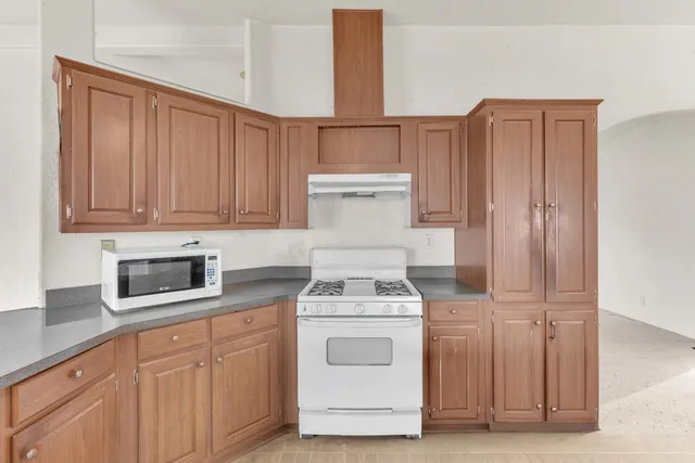 a kitchen with white cabinets and white appliances