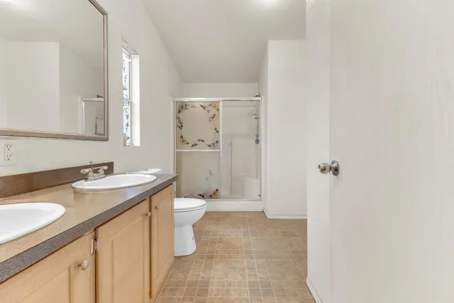 a bathroom with a granite countertop sink toilet and shower