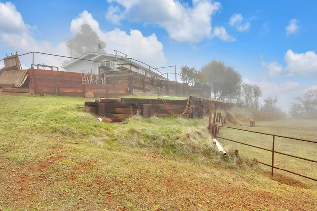 a view of a yard with wooden fence