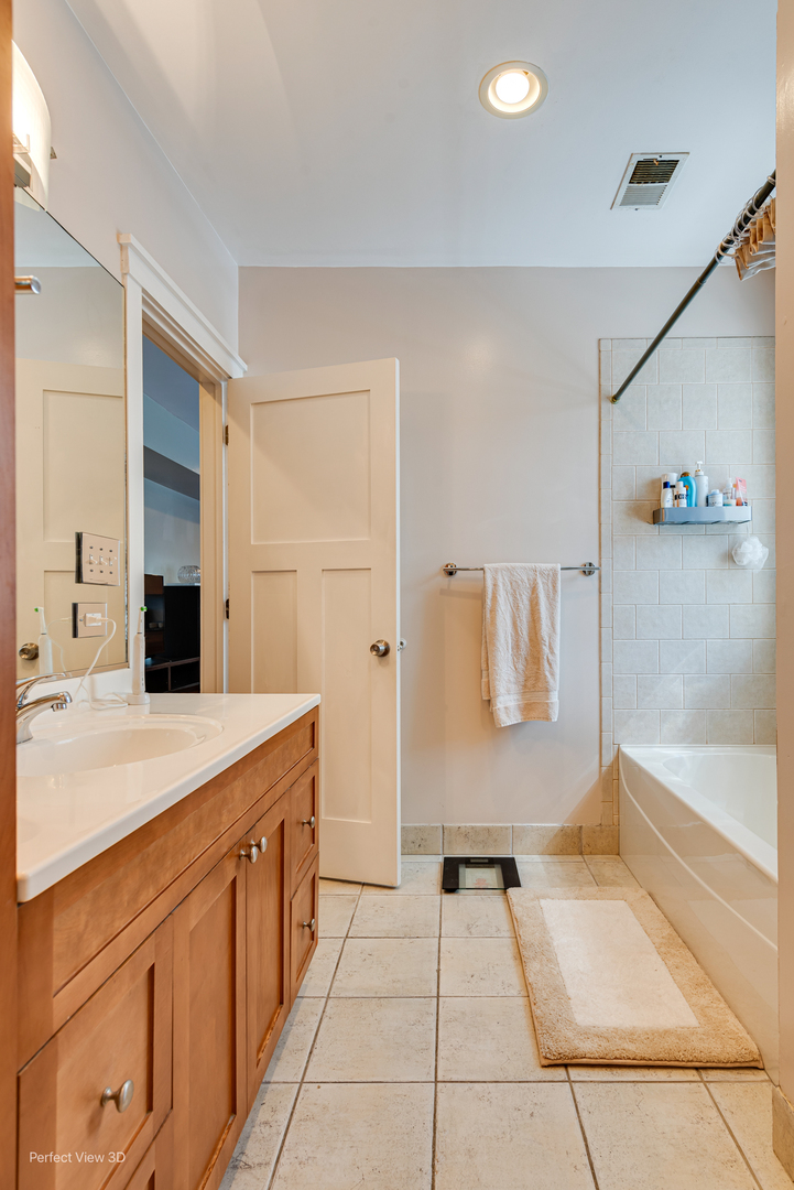 2111 West Arthur Avenue, Unit 1S Chicago, IL 60645 - Photo 12 of 27 a spacious bathroom with a tub sink and mirror