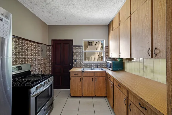 a kitchen with stainless steel appliances granite countertop a sink and a refrigerator