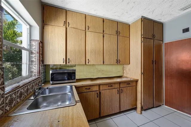 a kitchen with stainless steel appliances granite countertop a sink and a refrigerator