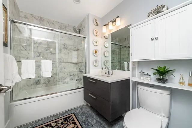 a bathroom with a granite countertop sink toilet and shower