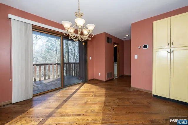 a kitchen with a refrigerator chandelier and wooden floor