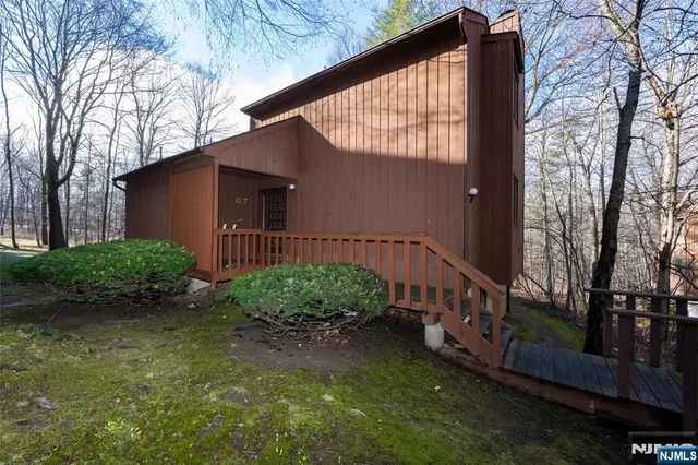 a view of a house with backyard and trees