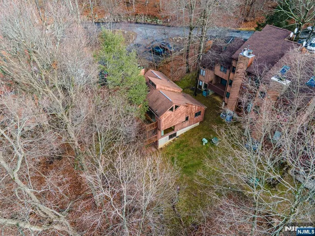 an aerial view of a house with a yard and large tree