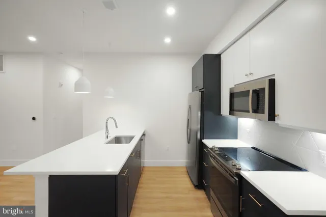 a kitchen with stainless steel appliances granite countertop a sink and a stove