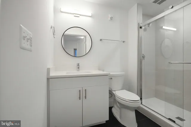 a bathroom with a toilet a sink a mirror and vanity
