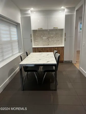a kitchen with a table chairs and a wooden floor