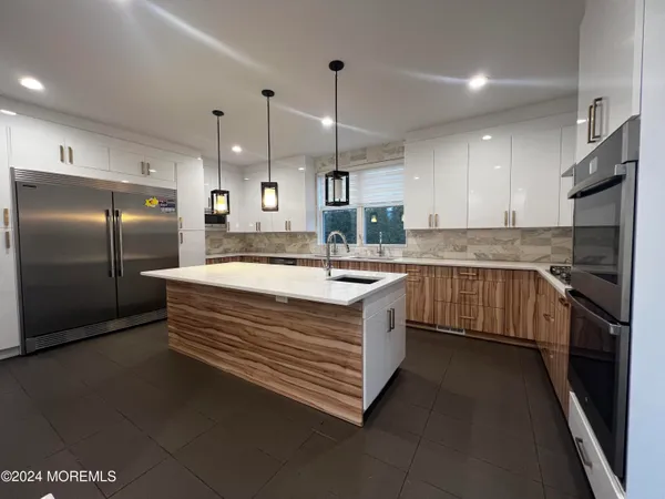 a kitchen with stainless steel appliances granite countertop a sink a stove and a refrigerator