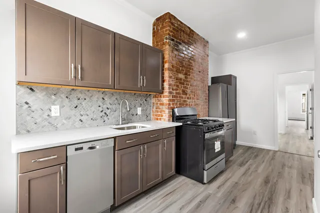 a kitchen with stainless steel appliances granite countertop a sink stove and refrigerator