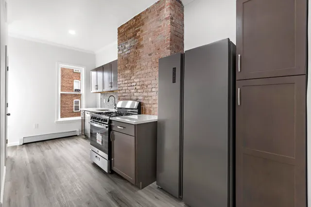 a kitchen with stainless steel appliances granite countertop a refrigerator and a stove top oven