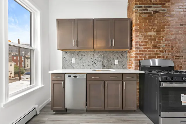 a kitchen with stainless steel appliances granite countertop a sink stove and cabinets