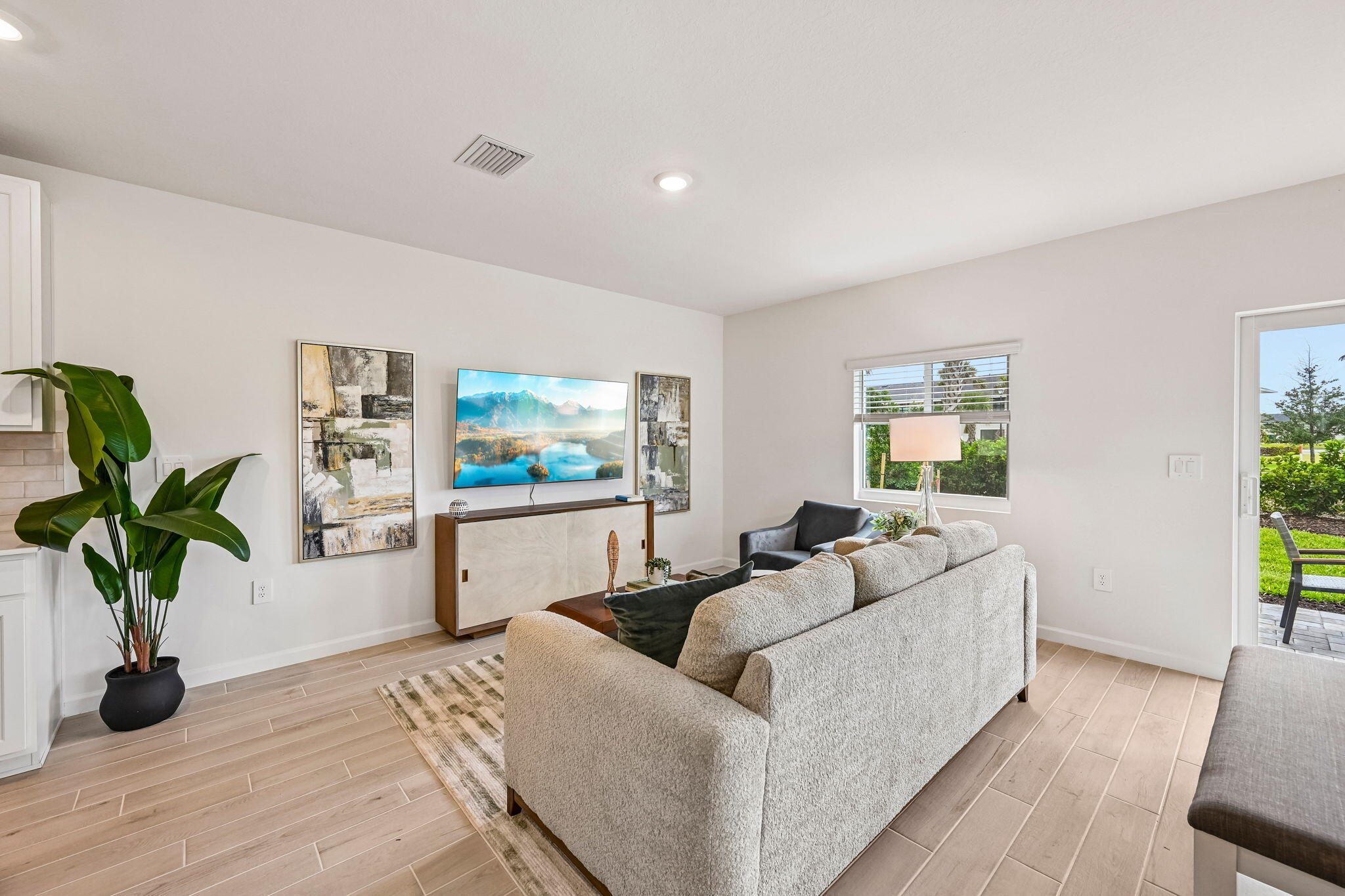 12957 Southwest Forli Way Port St. Lucie, FL 34987 - Photo 11 of 31 a living room with furniture a potted plant and a wooden floor