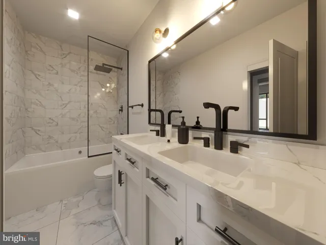 a bathroom with a double vanity sink toilet mirror and bathtub
