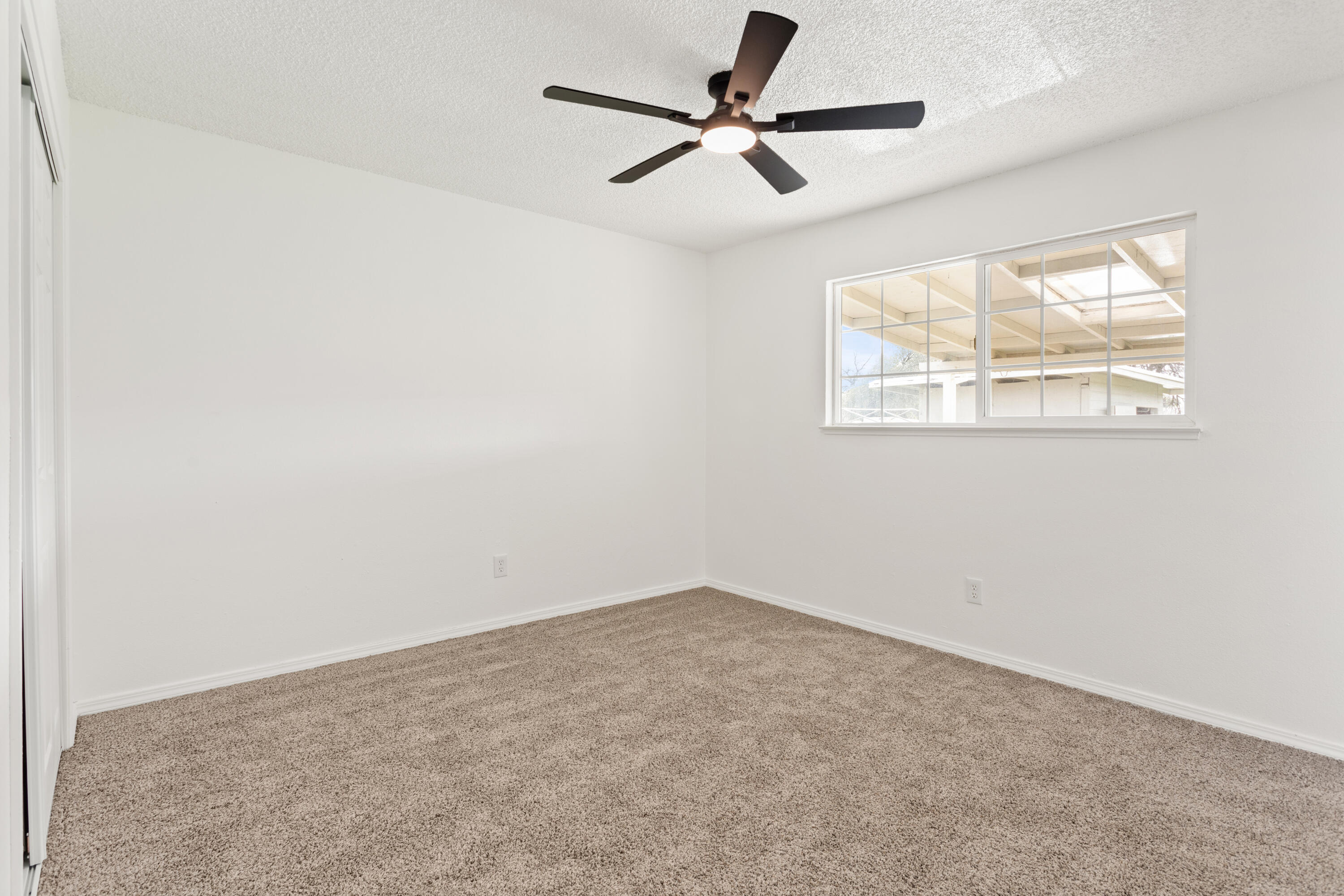 6973 Happy Valley Road Anderson, CA 96007 - Photo 23 of 36 an empty room with a window and a fan