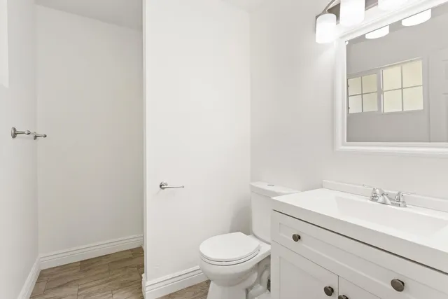 a bathroom with a granite countertop toilet and a sink