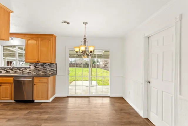 a view of empty room with wooden floor and windows
