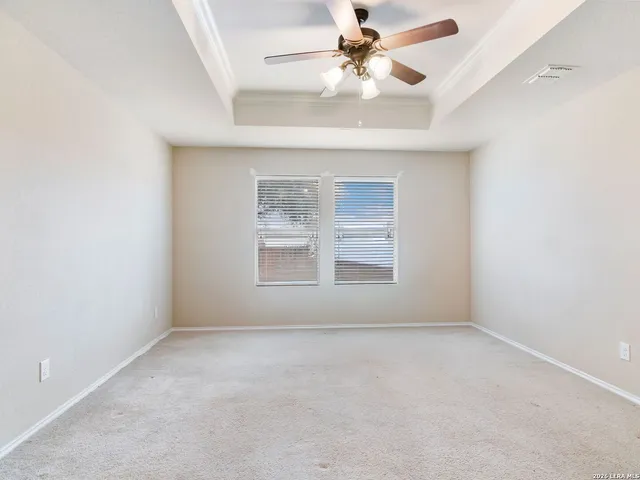 an empty room with a window and a fan