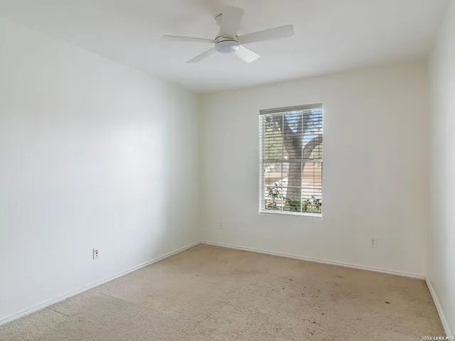 an empty room with a window and a fan