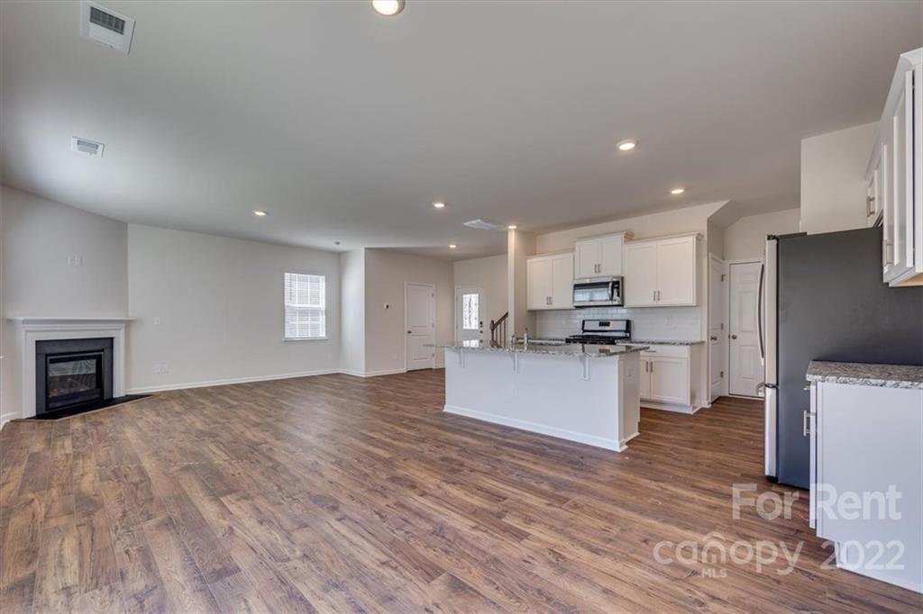 587 King Clover Lane Clover, SC 29710 - Photo 6 of 25 a large kitchen with stainless steel appliances kitchen island a large counter top and a stove top oven
