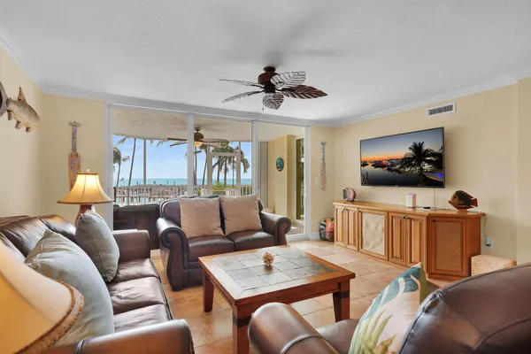 a living room with furniture a flat screen tv and a window