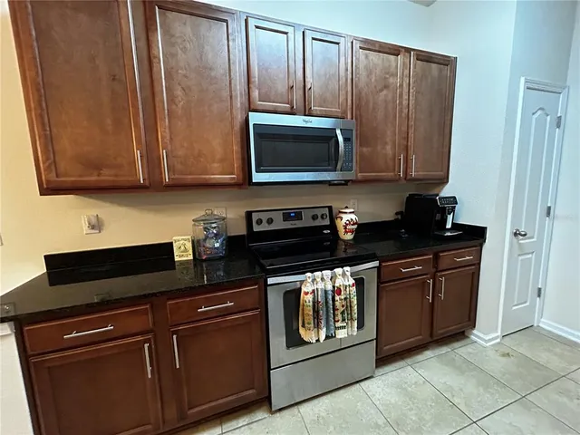 a kitchen with granite countertop cabinets and black appliances