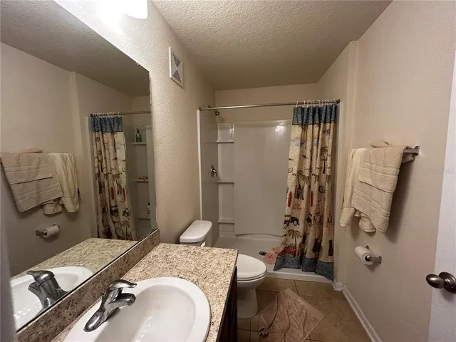 a bathroom with a granite countertop tub sink and mirror