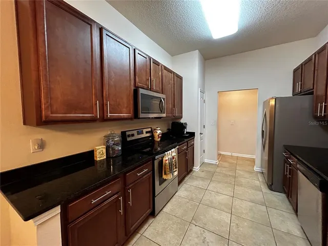 a kitchen with stainless steel appliances granite countertop a refrigerator and a stove top oven