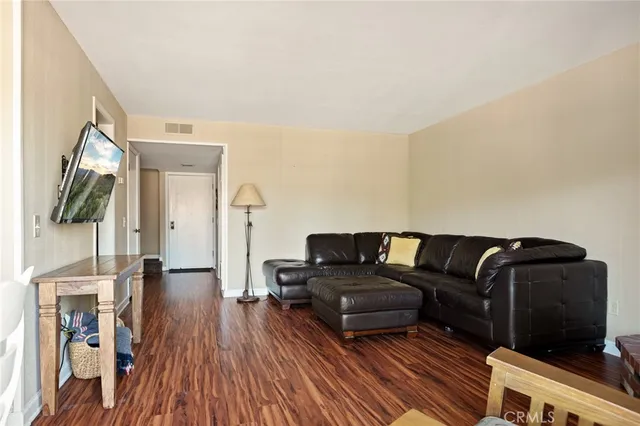 a living room with furniture a flat screen tv and a floor to ceiling window