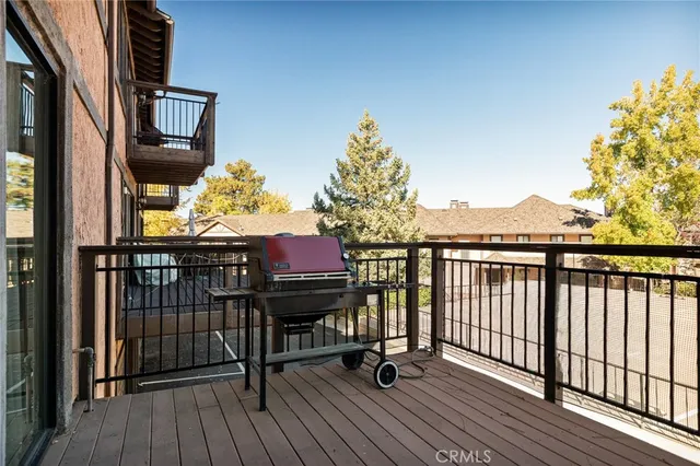 a view of a balcony with wooden floor and iron fence