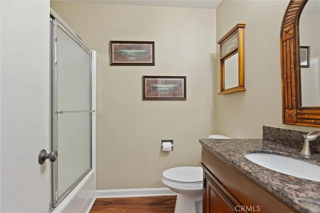 a bathroom with a granite countertop toilet and a sink
