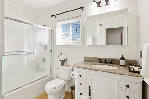 a bathroom with a granite countertop sink a toilet and a shower