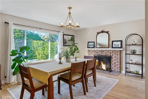 a dining room with furniture a fireplace and wooden floor