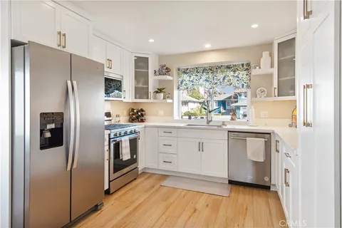 a kitchen with a refrigerator cabinets and wooden floor