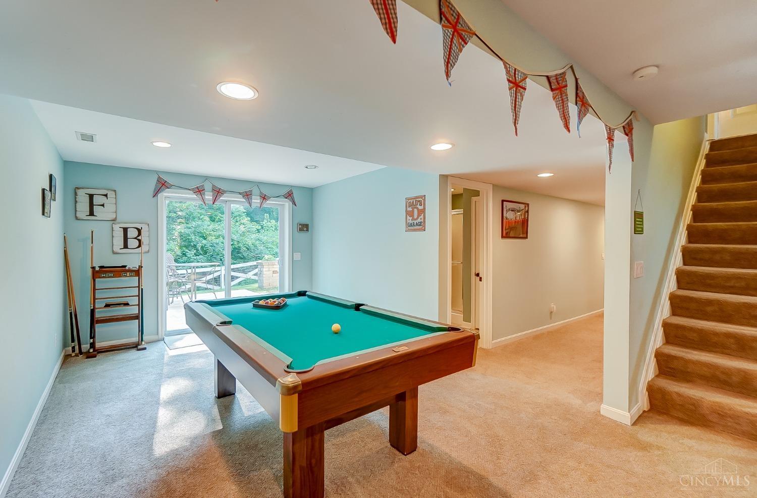 7272 Ayers Road Cincinnati, OH 45255 - Photo 35 of 54 Down the stairs to the lower level recreation room. Pool table can stay! Sliding doors open to the concrete patio entertaining area. Hallway is 5' wide and leads to the laundry room and storage.