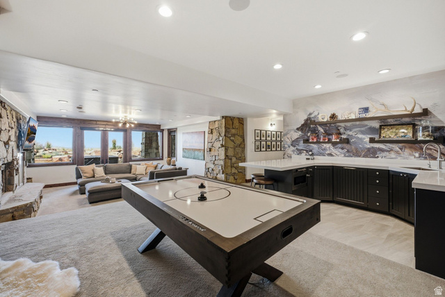 7885 North Rabbitbrush Court, Unit 13 Park City, UT 84098 - Photo 40 of 88 Spacious entertainment room featuring a stone-clad fireplace, large windows, recessed lighting, and a built-in wet bar with dark cabinetry and light countertops