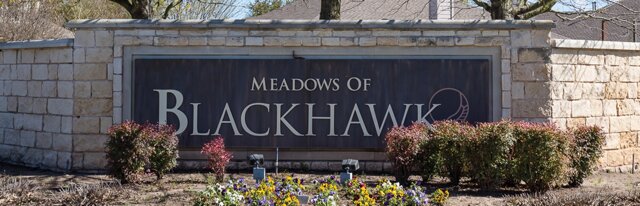 20724 Kearney Hill Road Pflugerville, TX 78660 - Photo 34 of 40 Stone masonry entrance sign featuring a dark central panel, carved lettering, and integrated landscaping with flowering plants and shrubbery