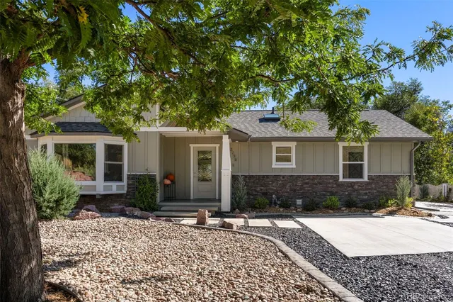 a front view of a house with a yard and potted plants