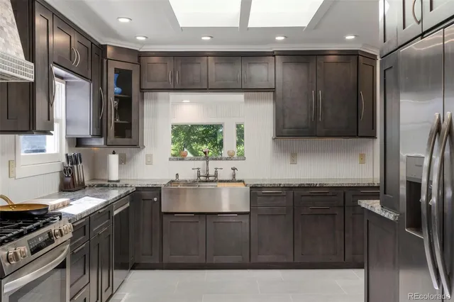 a kitchen with stainless steel appliances a sink stove and refrigerator