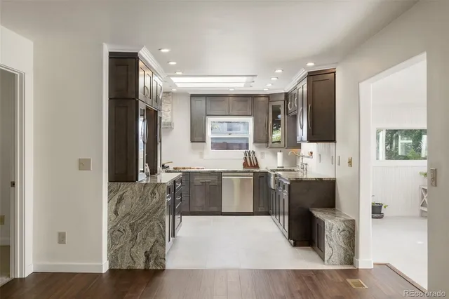 a kitchen with stainless steel appliances granite countertop a refrigerator and a stove top oven