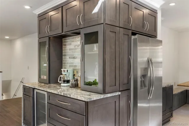 a kitchen with stainless steel appliances granite countertop a refrigerator and a sink