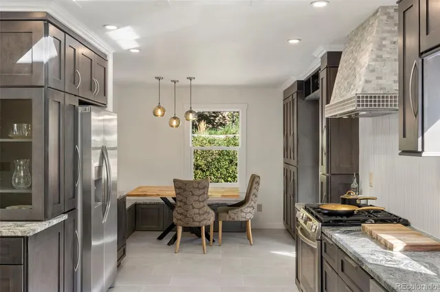 a kitchen with stainless steel appliances granite countertop a stove a refrigerator and a dining table