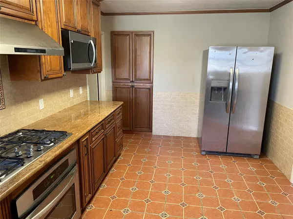 a kitchen with stainless steel appliances granite countertop a refrigerator and a stove
