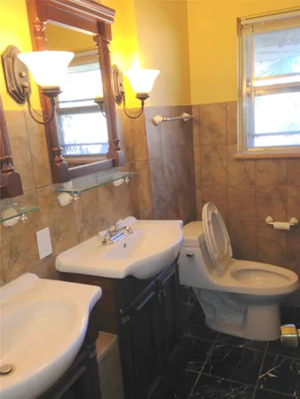 a bathroom with a sink toilet and mirror