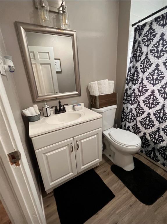 3209 North 23rd Street Waco, TX 76708 - Photo 5 of 8 a bathroom with a toilet a sink and a mirror