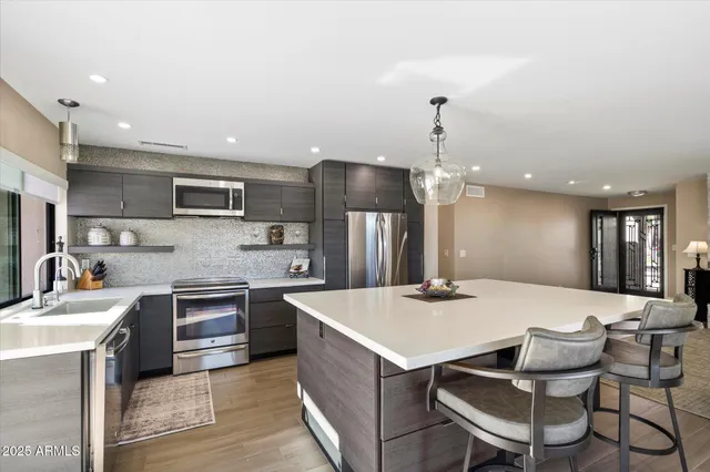 a kitchen with sink refrigerator and dining table