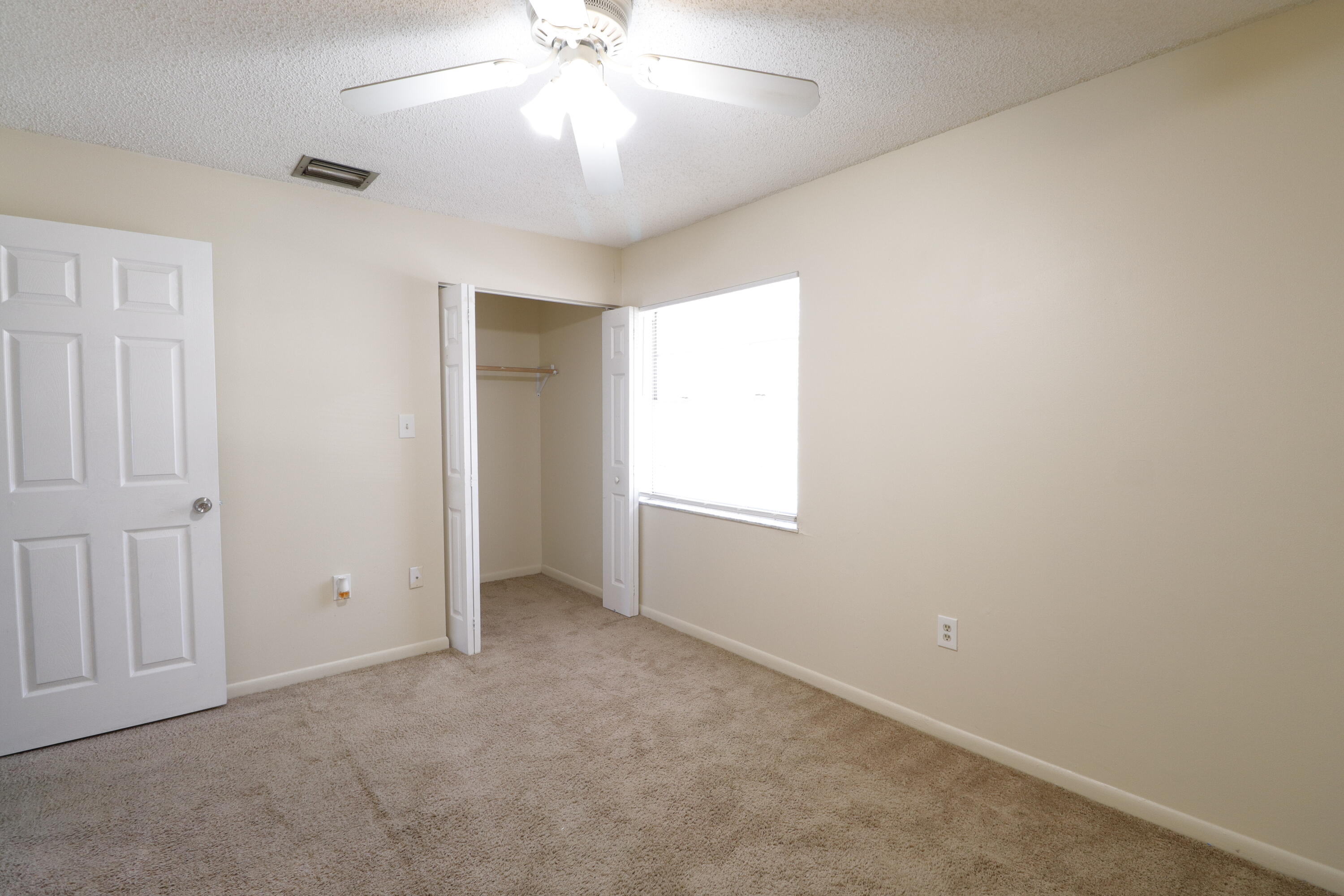 2016 South 10th Street, Unit A Fort Pierce, FL 34950 - Photo 7 of 13 an empty room with a chandelier fan and windows