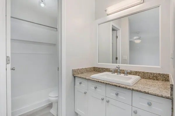 a bathroom with a granite countertop sink toilet and shower