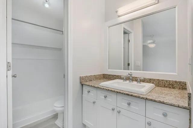 a bathroom with a granite countertop sink toilet and shower